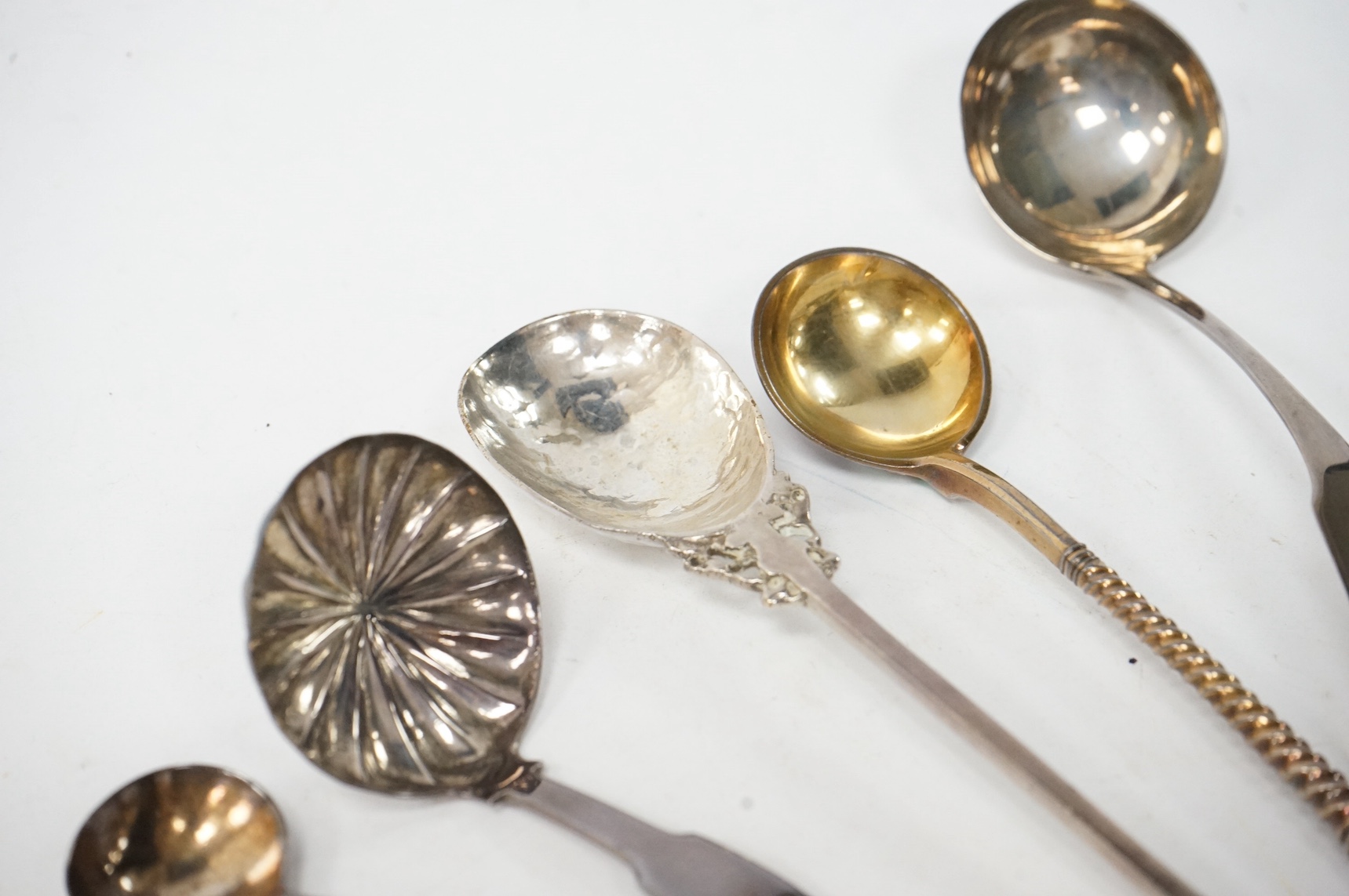 A George VI Arts & Crafts silver seal top spoon by Amy Sandheim, London, 1948, 14.2cm, a 19th century Russian 88 zolotnik and enamel spoon, assay master B.C, 1874, a 19th century silver caddy spoon and three silver ladle